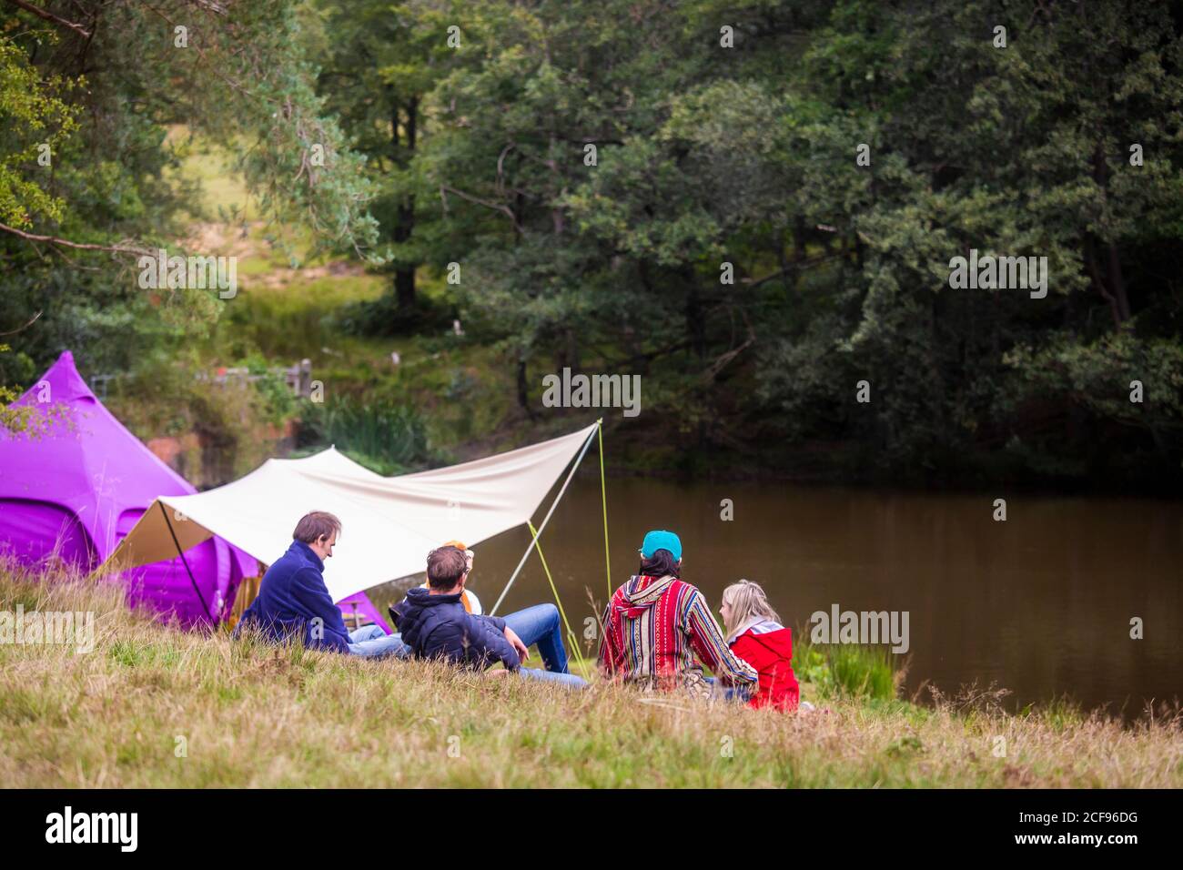 Chilling by the lake in the wellbeing area at We Are Not a Festival socially distanced event in Pippingford Park - camping with a festival vibe Stock Photo