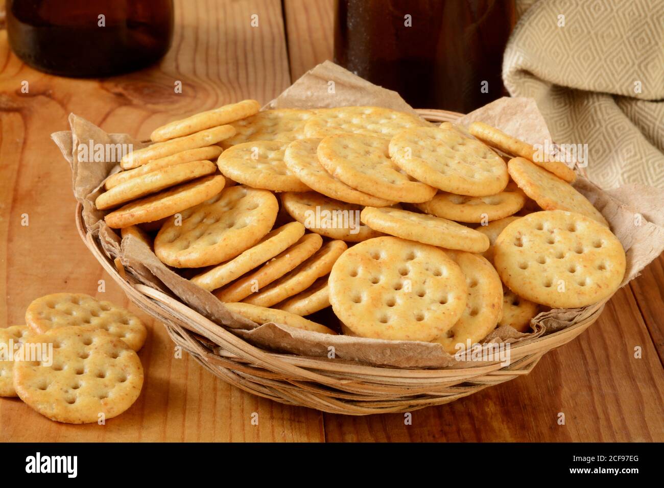 a basket of multi grain crackers with bottles of beer on a bar counter Stock Photo