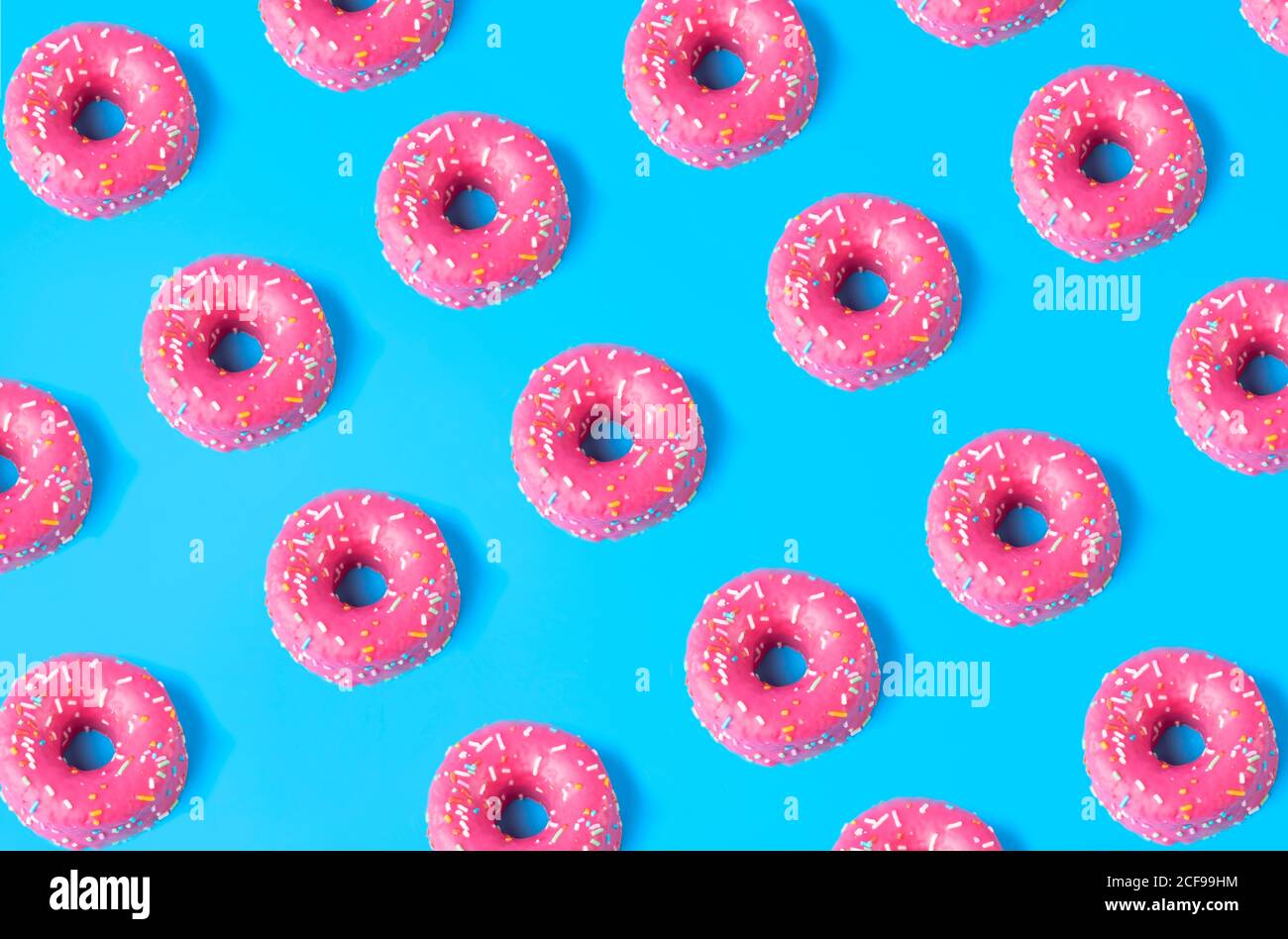 Seamless pattern from pink sweet doughnuts placed on blue background Stock Photo