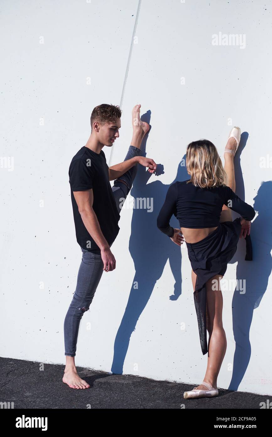 Full length of flexible couple standing looking at each other and doing