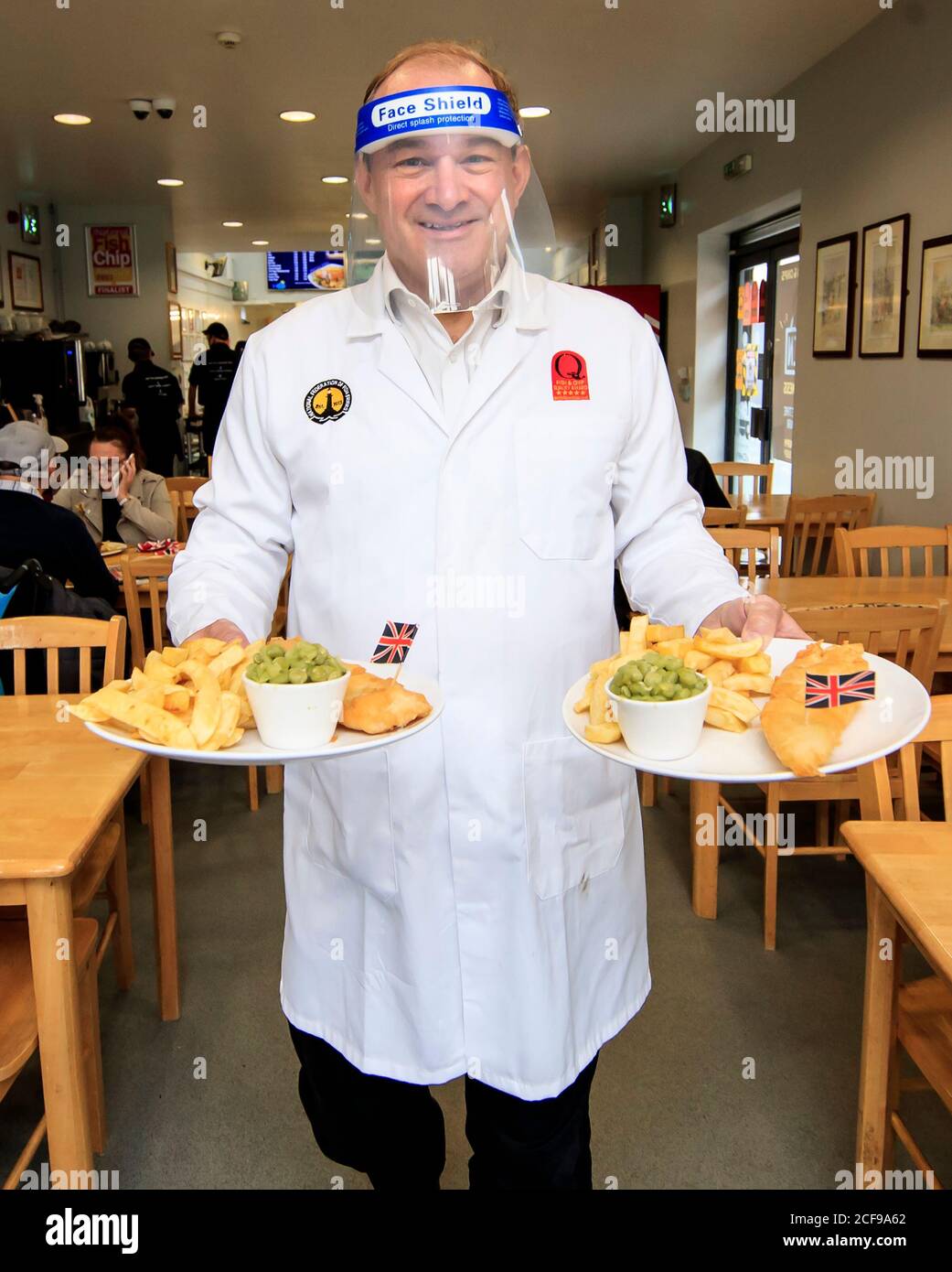 Liberal Democrat leader Ed Davey undertakes a 'shift' in Taylor's chip shop, in Stockport, during the start of his national listening tour. Stock Photo