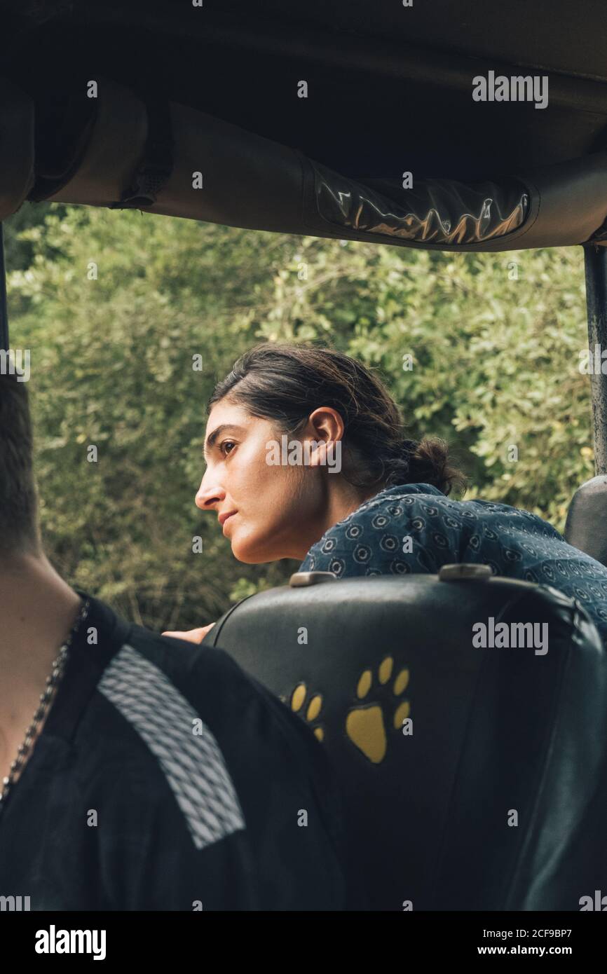 Traveling female sitting in automobile and admiring wonderful view of wildlife park Stock Photo