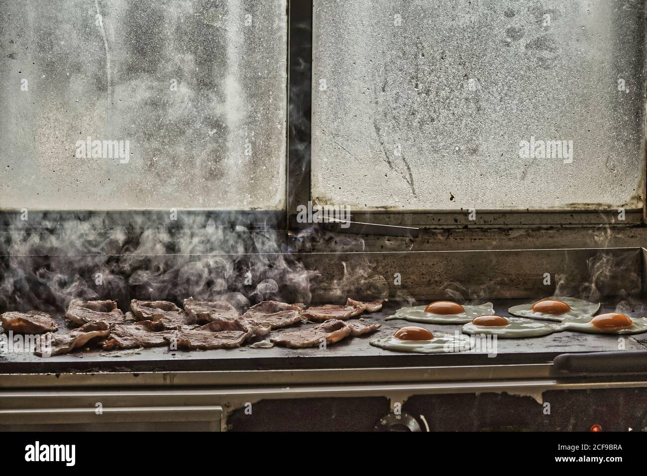 Traditional English breakfast in preparation on the grill at Felixstowe Ferry  - Suffolk's quirky 'olde World' fishing village Stock Photo