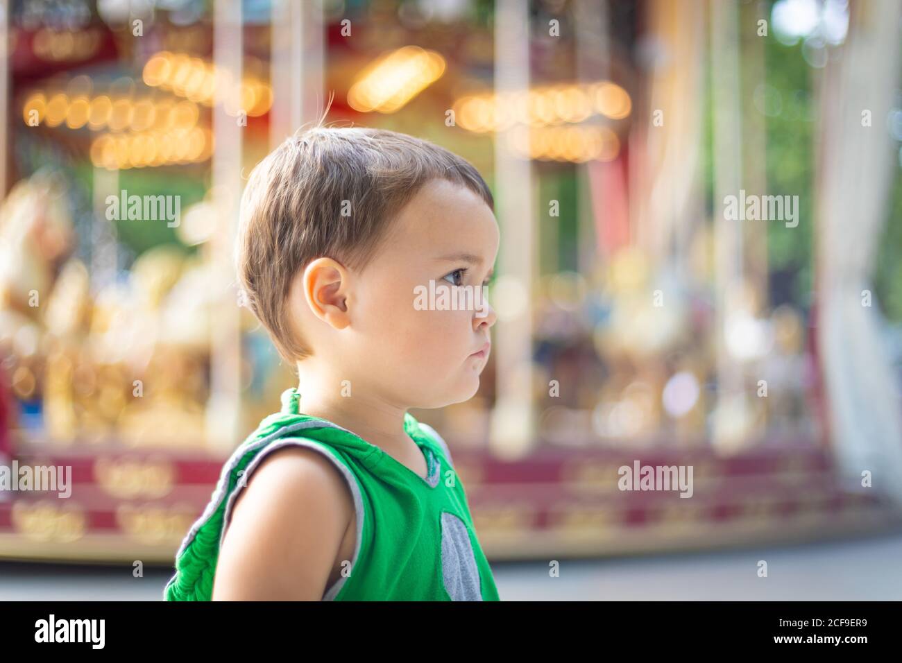 Child looking away against moving carousel at fair Stock Photo