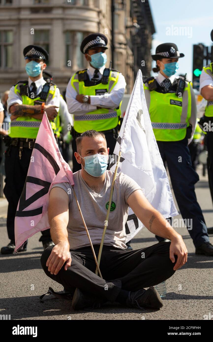 A protester blocking a road during an Extinction Rebellion demonstration, Parliament Square, London, 2 September 2020 Stock Photo