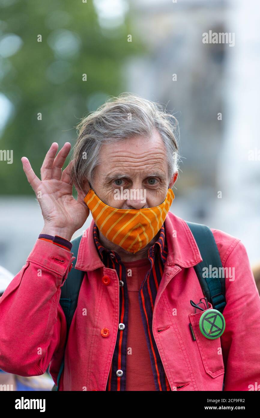 An elderly protester with hand cupped to ear, Extinction Rebellion demonstration, Parliament Square, London, 2 September 2020 Stock Photo