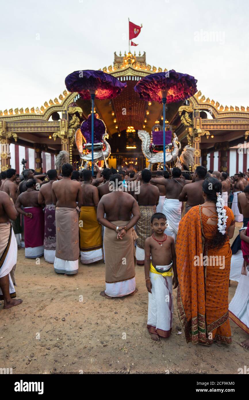 Jaffna, Sri Lanka - August, 7 2019: Many Tamil people carrying incenses and Murugan god near ornamental temple entrance during Nallur Kandaswamy Kovil Festival Stock Photo