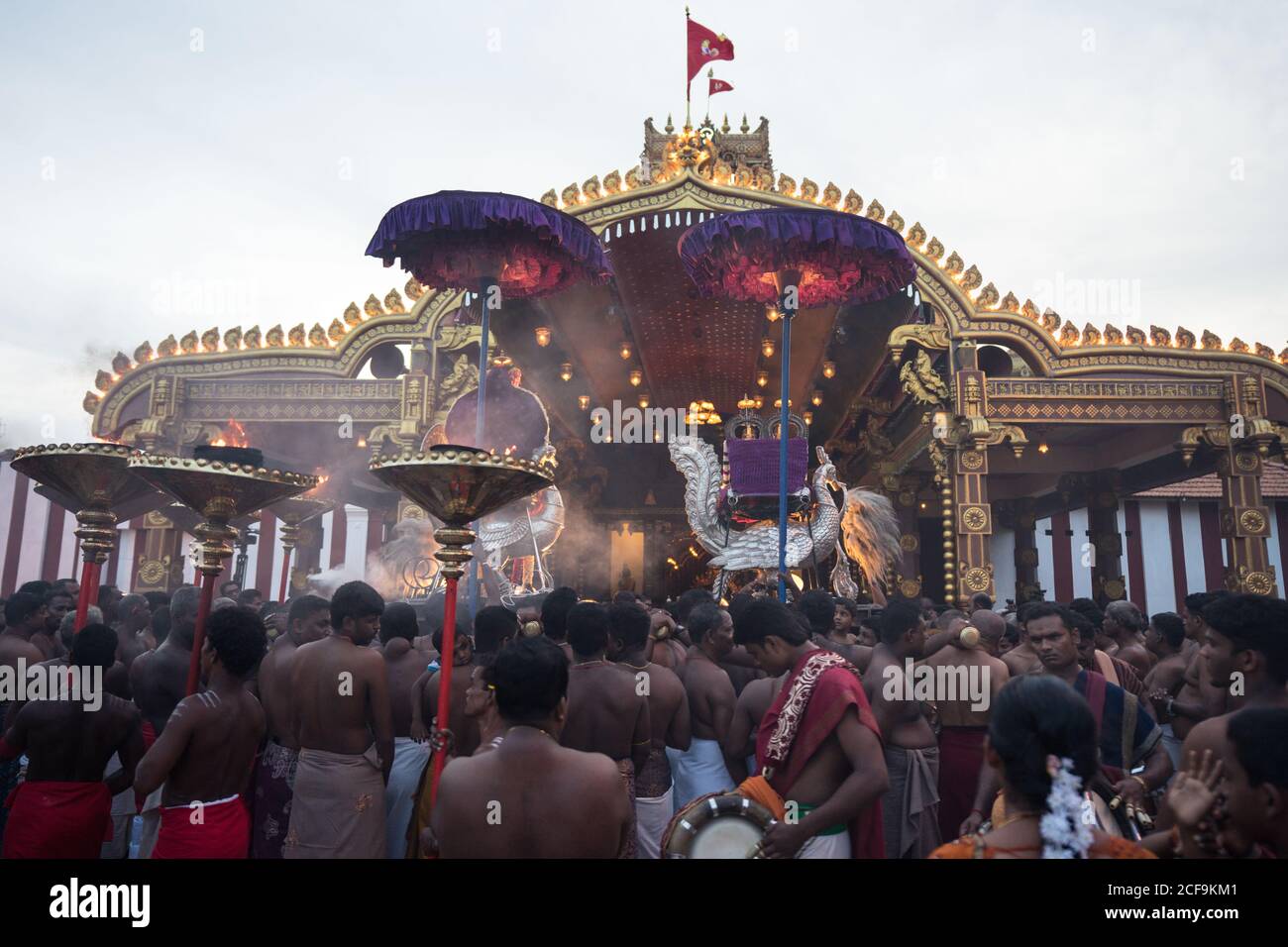 Jaffna, Sri Lanka - August, 7 2019: Many Tamil people carrying incenses and Murugan god near ornamental temple entrance during Nallur Kandaswamy Kovil Festival Stock Photo