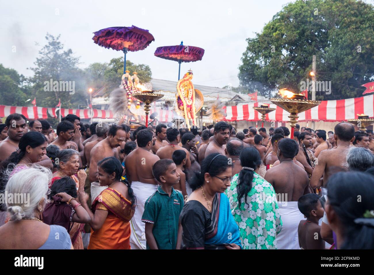 Jaffna, Sri Lanka - August, 7 2019: Many Tamil people carrying incenses and Murugan god near ornamental temple entrance during Nallur Kandaswamy Kovil Festival Stock Photo