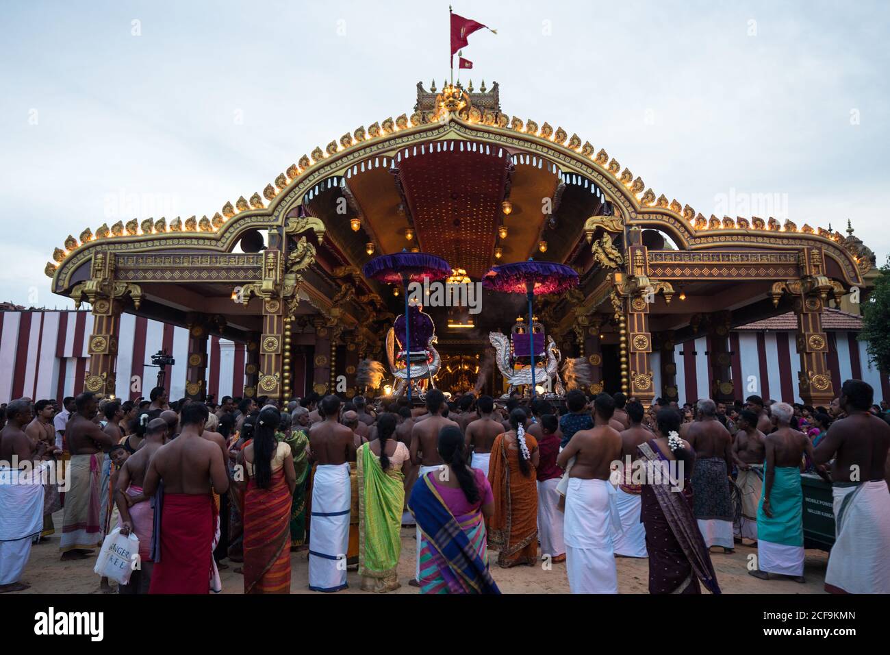 Jaffna, Sri Lanka - August, 7 2019: many Tamil people carrying incenses and Murugan god near ornamental temple entrance during Nallur Kandaswamy Kovil Festival Stock Photo