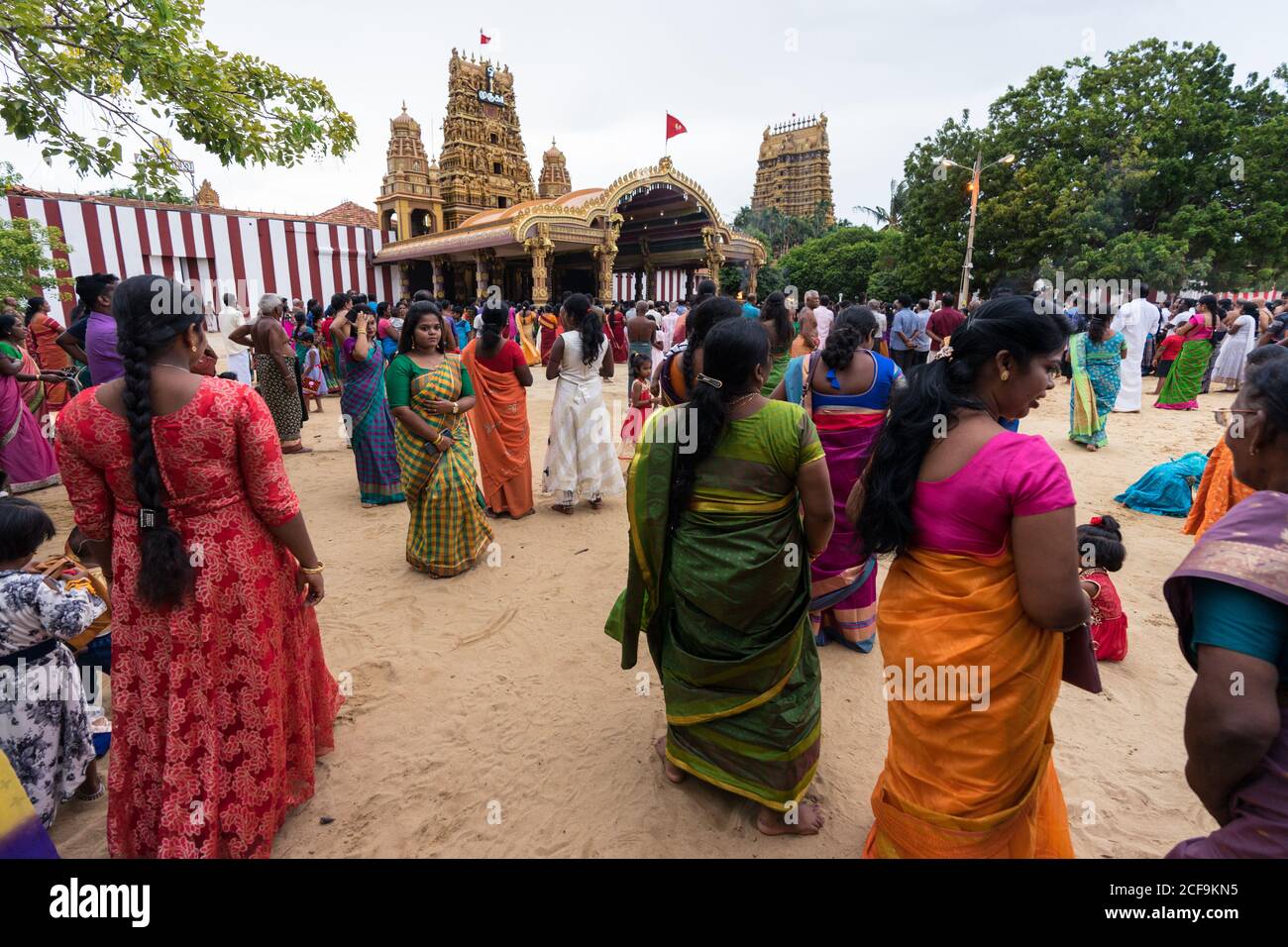 jaffna sri lanka august 9 2019 young tamil female in colorful traditional clothes while standing against crowd and temple during nallur kandaswamy kovil festival 2CF9KN5