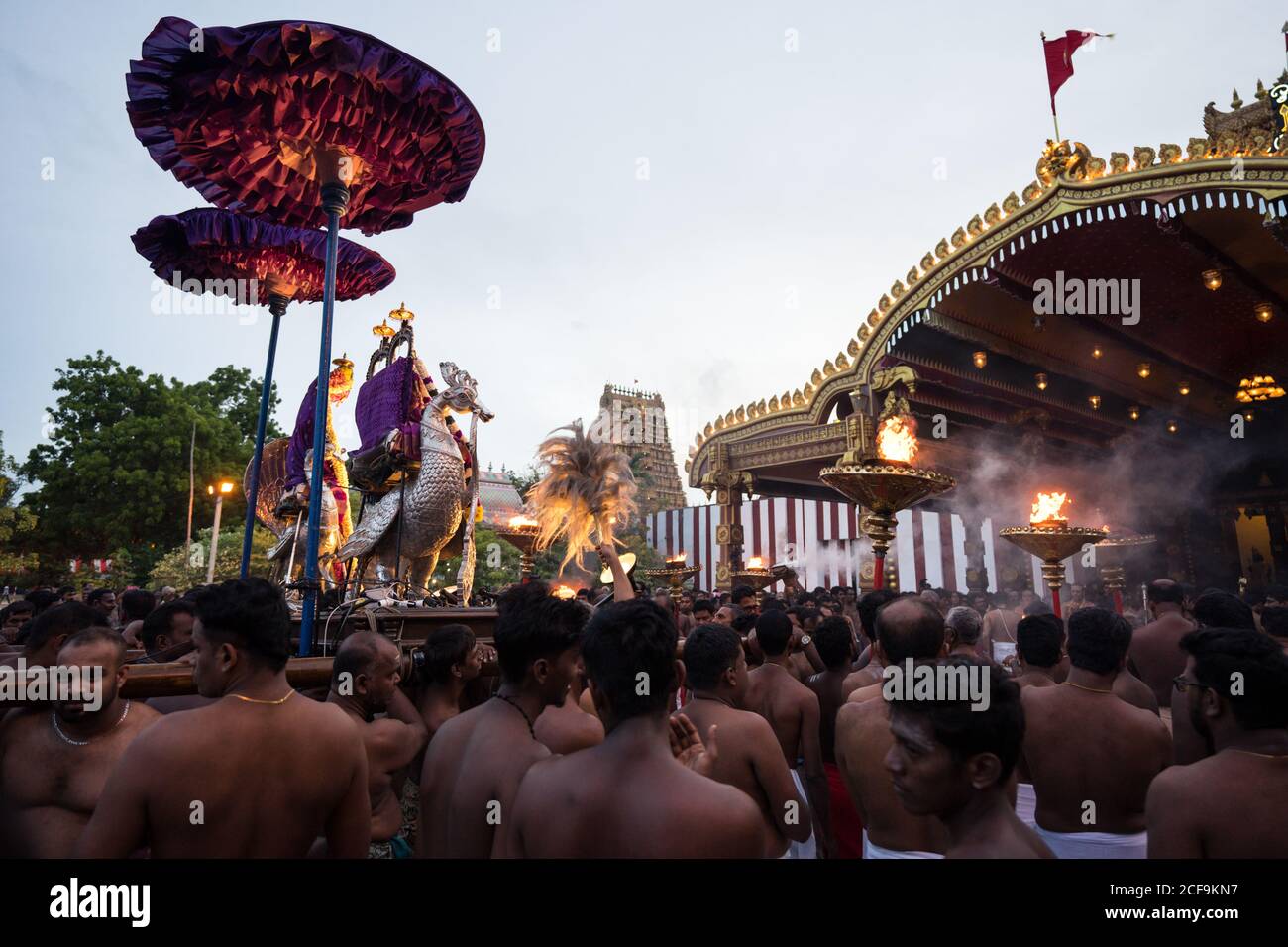 Jaffna, Sri Lanka - August, 7 2019: Many Tamil people carrying incenses and Murugan god near ornamental temple entrance during Nallur Kandaswamy Kovil Festival Stock Photo