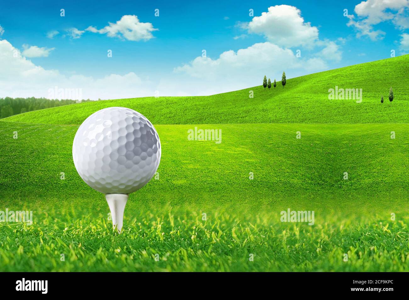 Golf ball on tee in green grass at golf course Stock Photo