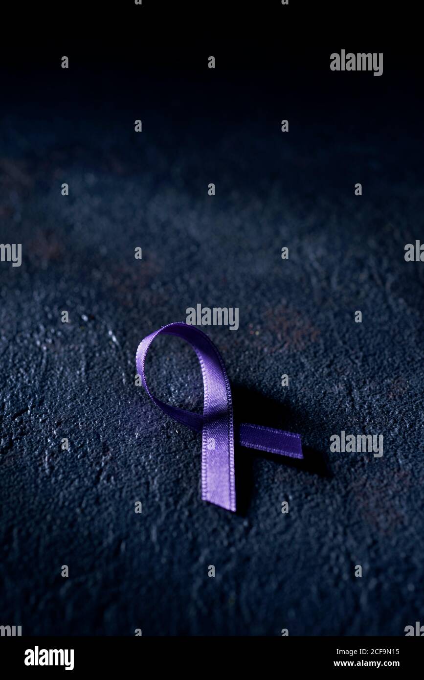 a purple awareness ribbon, for Alzheimers disease awareness, on a black ...