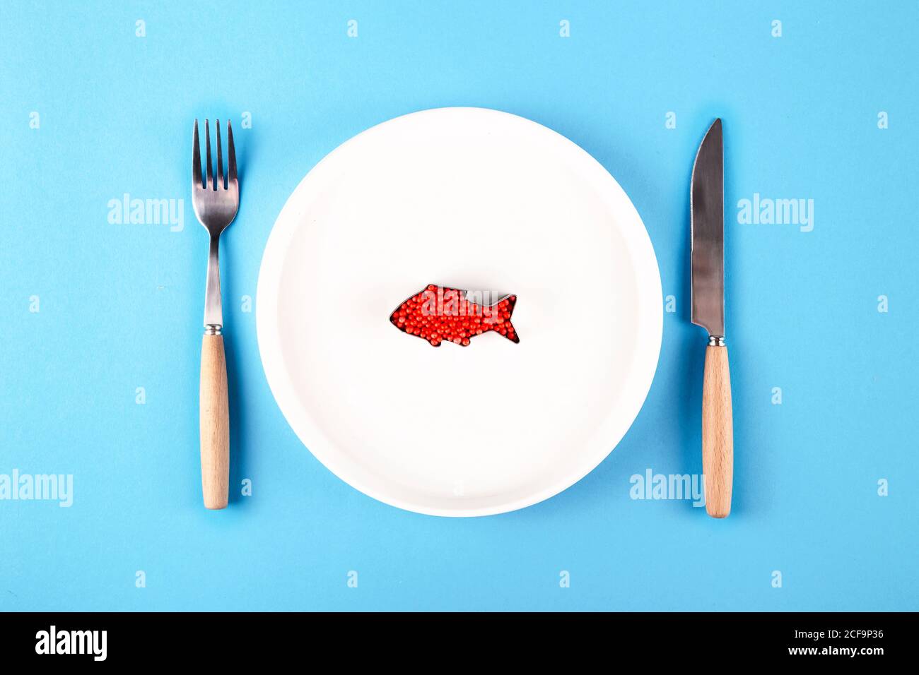 Plastic fish in a plate harmful substances in food concept Stock