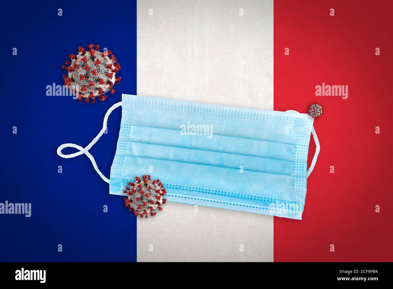 Concept of Coronavirus or Covid-19 particles and surgical face mask over flag of France in background. Stock Photo