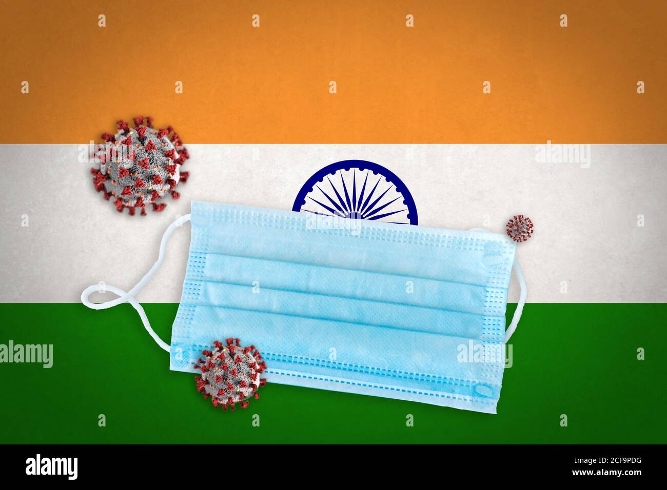 Concept of Coronavirus or Covid-19 particles and surgical face mask over flag of India in background. Stock Photo