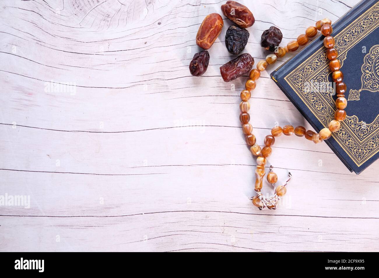 Holy book Quran and date fruit on wooden table  Stock Photo