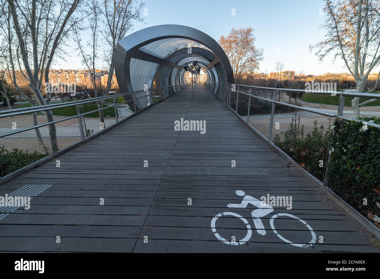 Perspective view of paved wooden bike path going to futuristic gallery ...