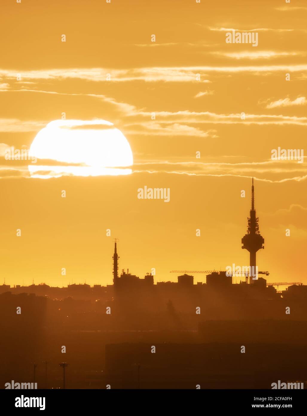 Magnificent cityscape with silhouettes of buildings on background of bright sun and amazing sundown Stock Photo