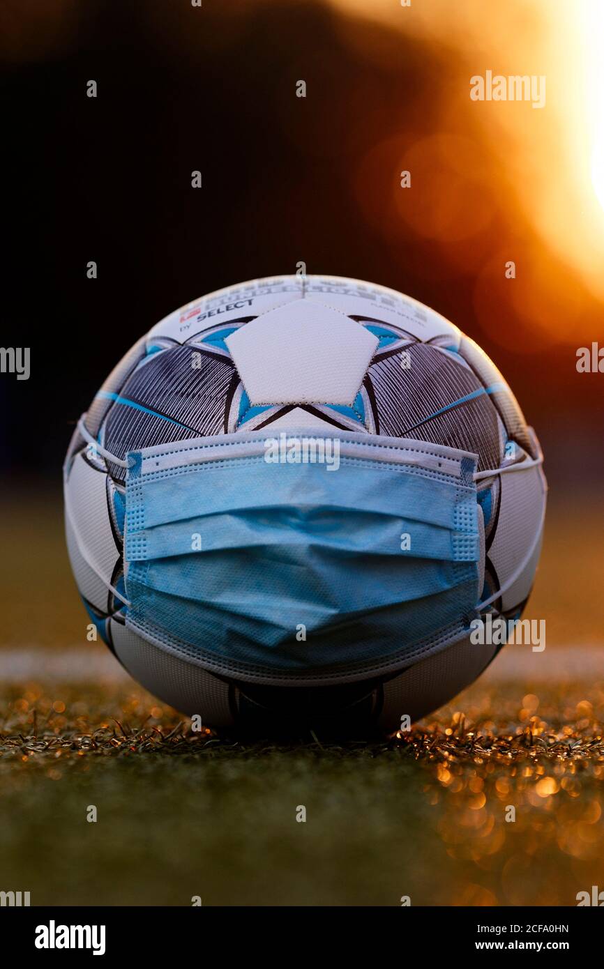 The official match ball of the Bundesliga Derbystar lies with a face mask on a football field. Konigsdorf, 02.09.2020 | usage worldwide Stock Photo