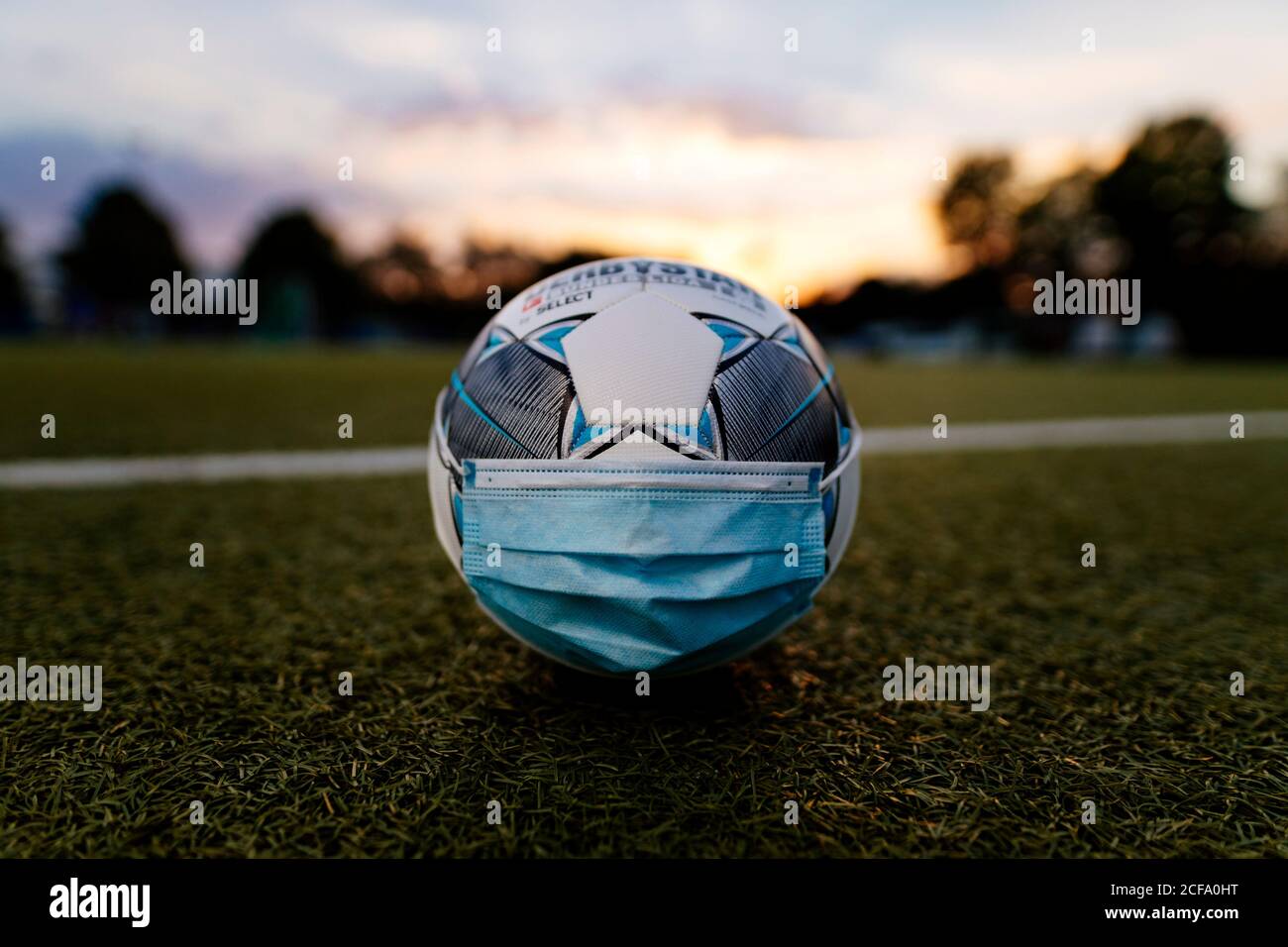 The official match ball of the Bundesliga Derbystar lies with a face mask on a football field. Konigsdorf, 02.09.2020 | usage worldwide Stock Photo