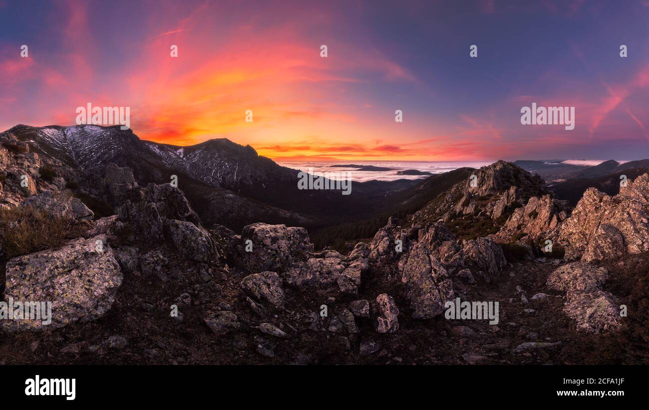 Breathtaking view of mountain ridge located against vivid sundown sky in cloudy evening in nature Stock Photo