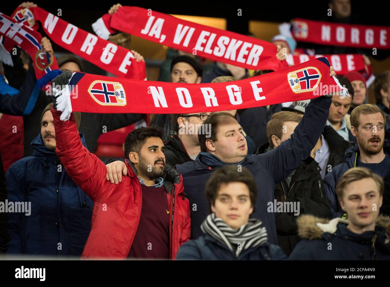 Norwegian football fans stand side-by-side during the national anthem  before the play-off match against Hungary at Ullevaal stadium in Oslo  (Gonzales Photo/Jan-Erik Eriksen Stock Photo - Alamy
