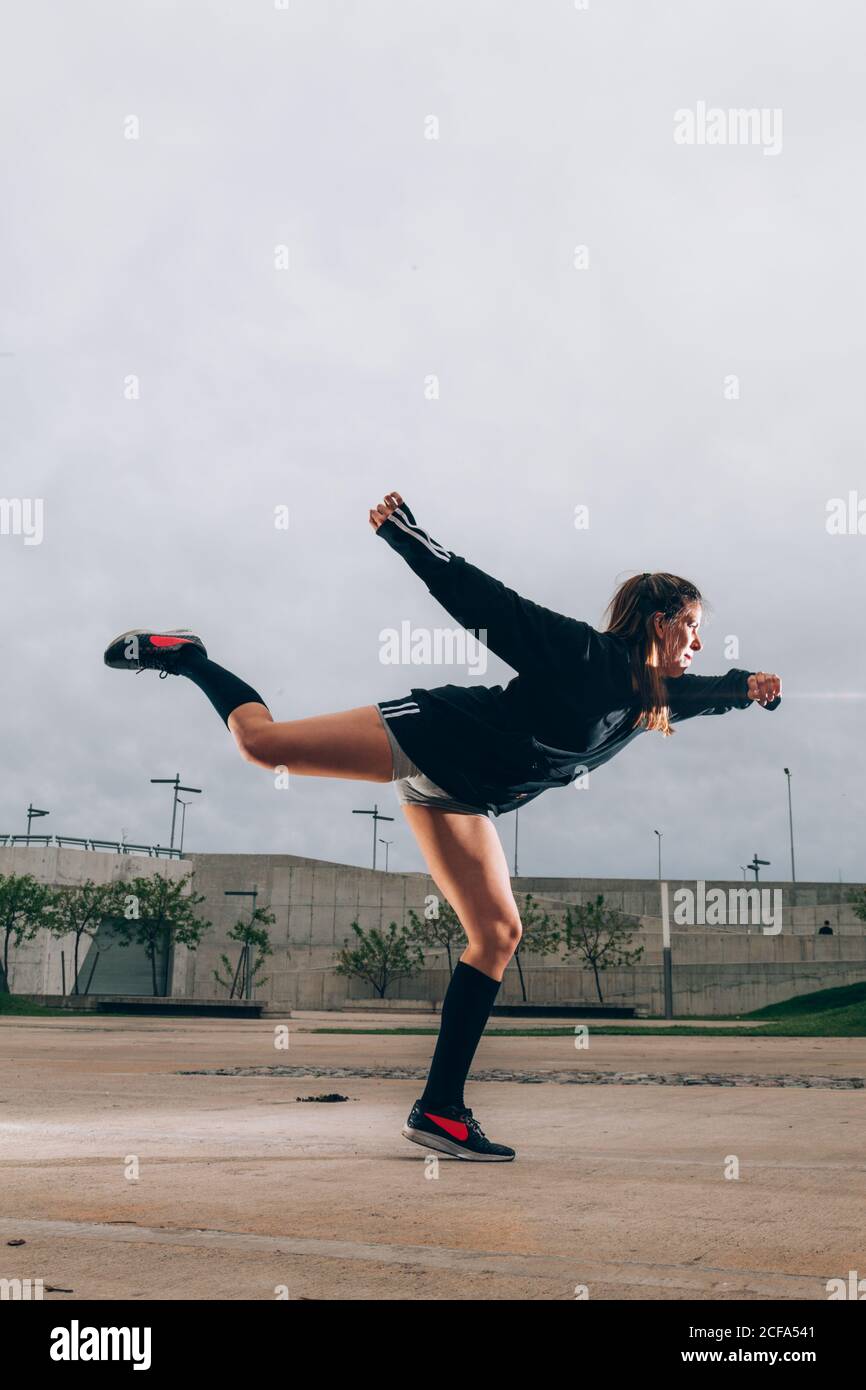 Female hip hop dancer in active wear striking pose outdoors Stock Photo