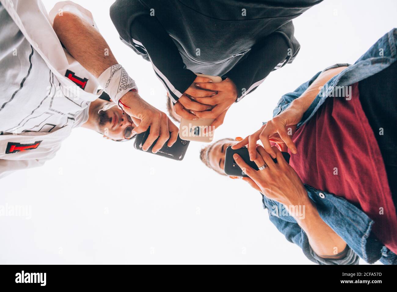 Stylish teenagers using smartphone outdoors Stock Photo