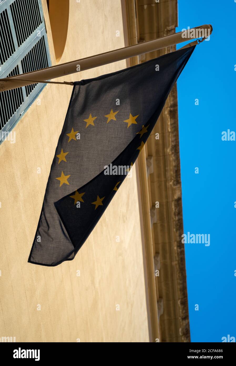 Low angle shot of an EU flag on a building on a blue sky background Stock Photo