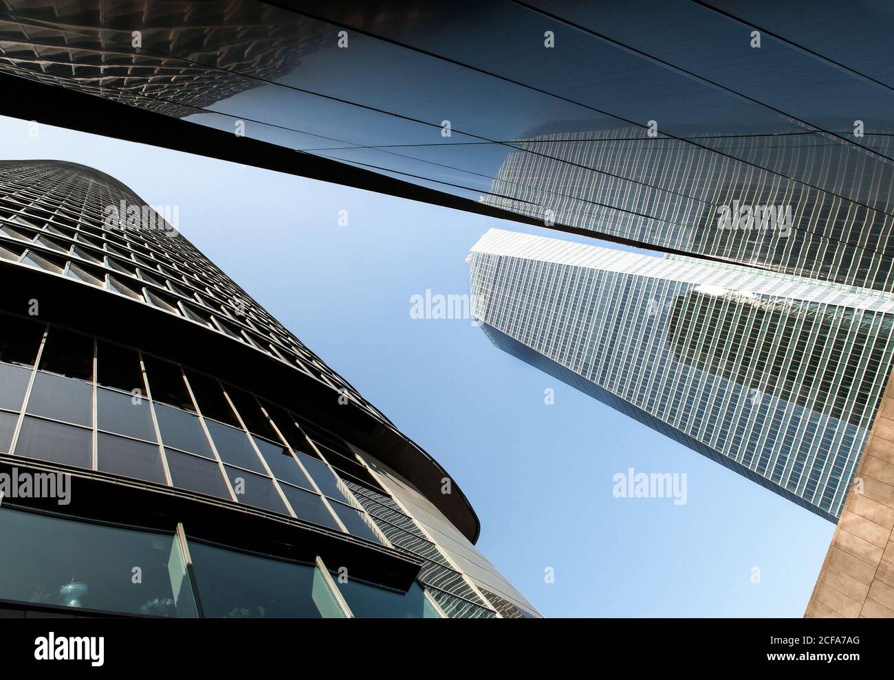 Perspective from below view of high rise towers with reflective glass facades in sunlight Stock Photo