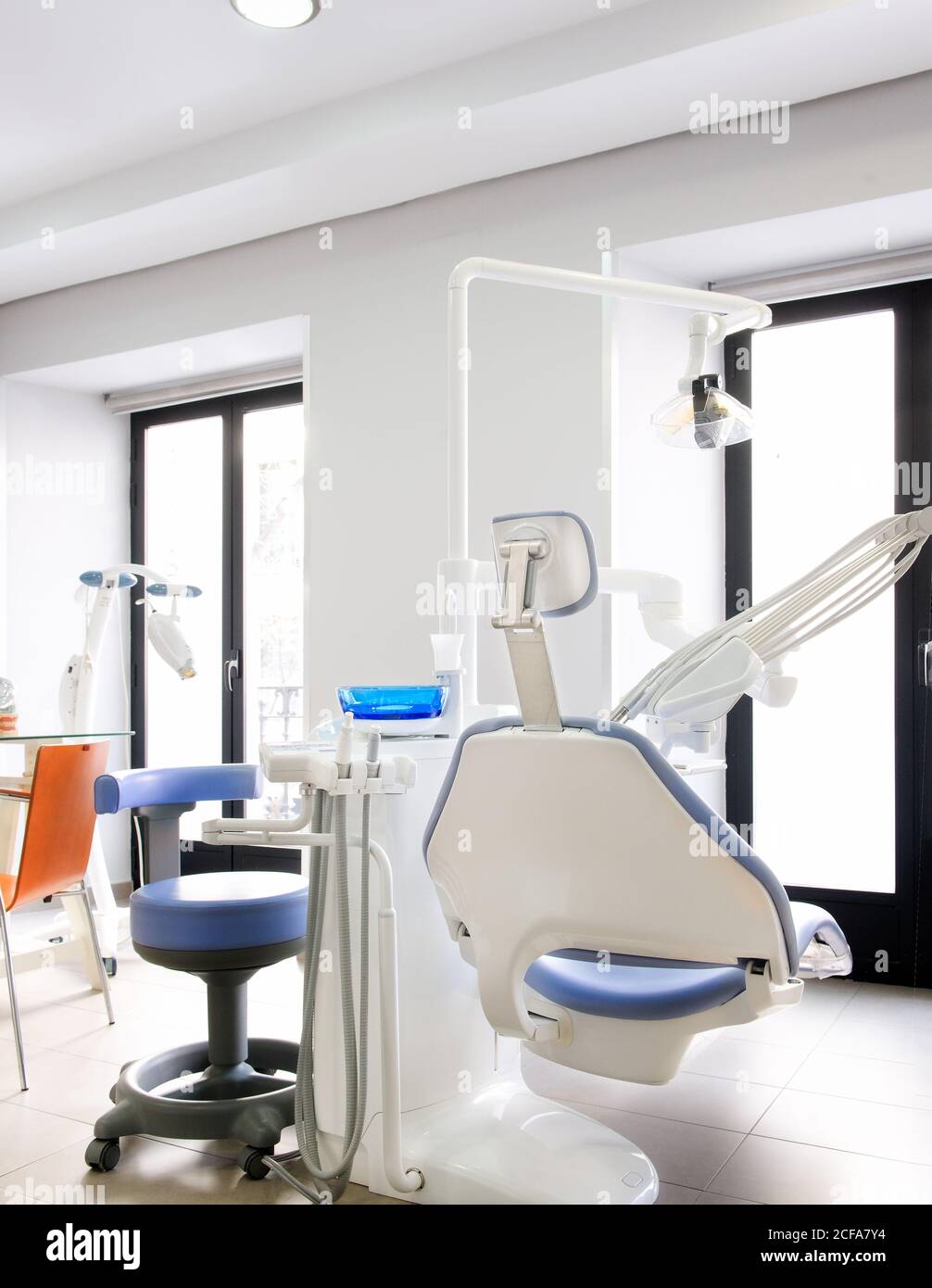 Leather dental chair with various medical instruments located in white dentist office Stock Photo