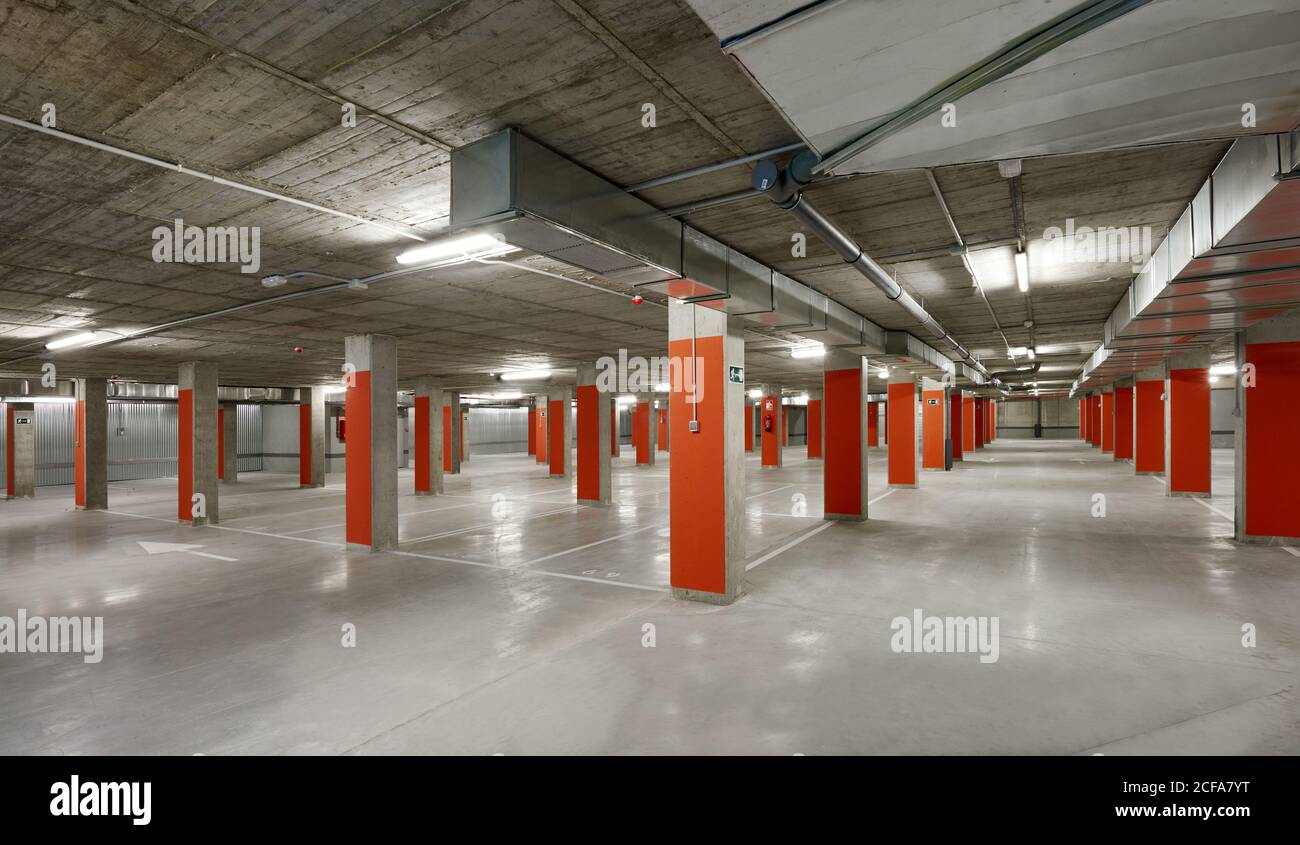 Modern parking lot with yellow stone columns and concrete floor located