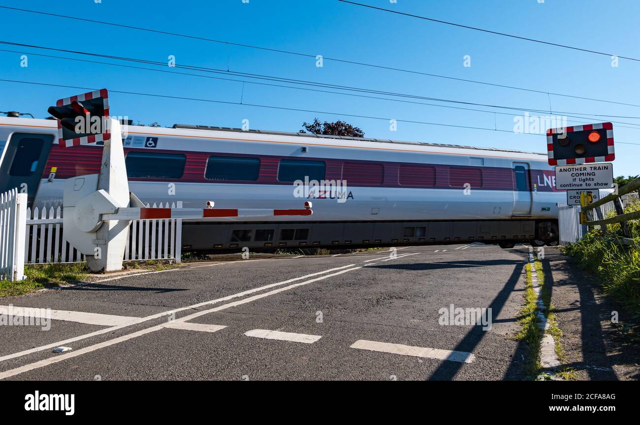 LNER Azuma train on East Coast mainline railway line level crossing