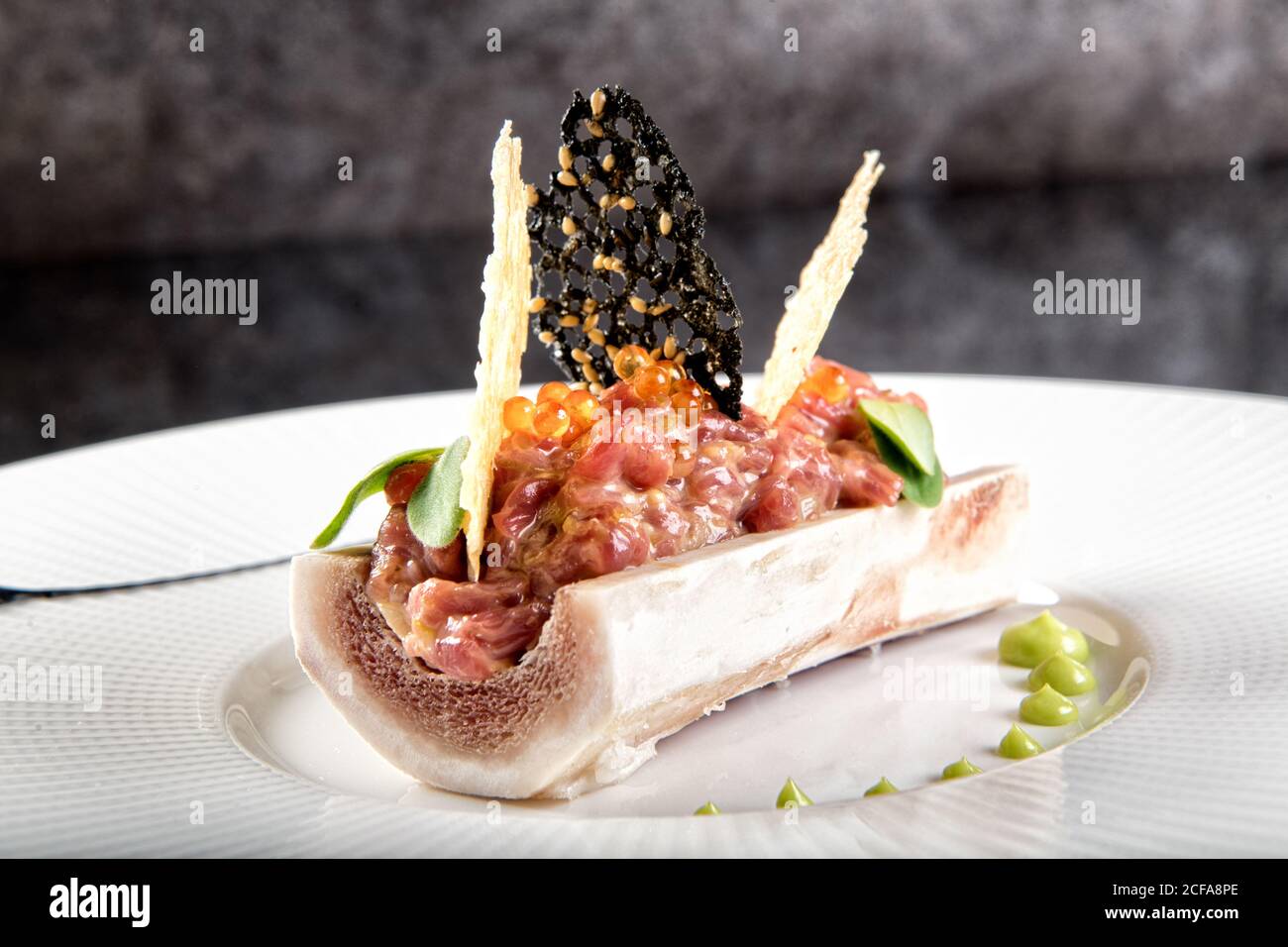 Closeup of exquisite restaurant dish of bone marrow with serving of
