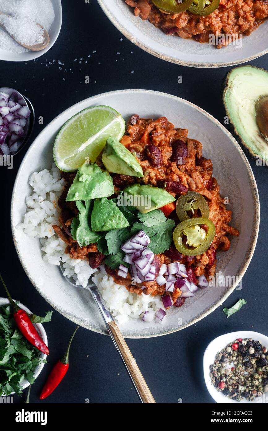 Served chili with rice and vegetables on table Stock Photo