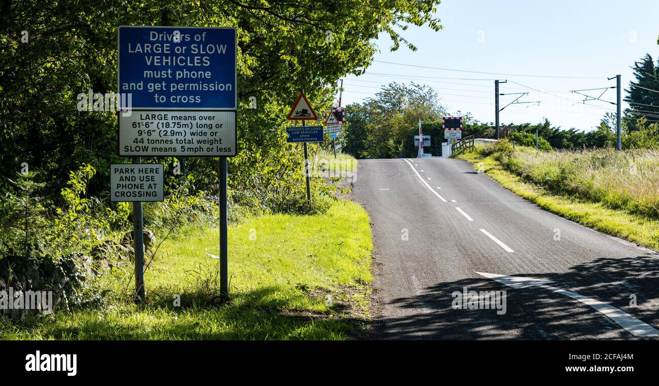 Warning road sign at East Coast mainline railway line level crossing