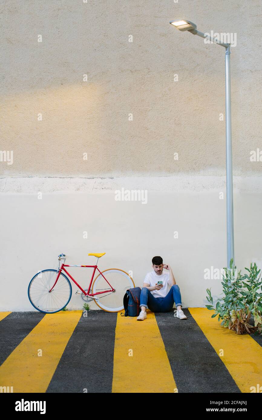 Front view of a man sitting on the floor with a fixie bike Stock Photo