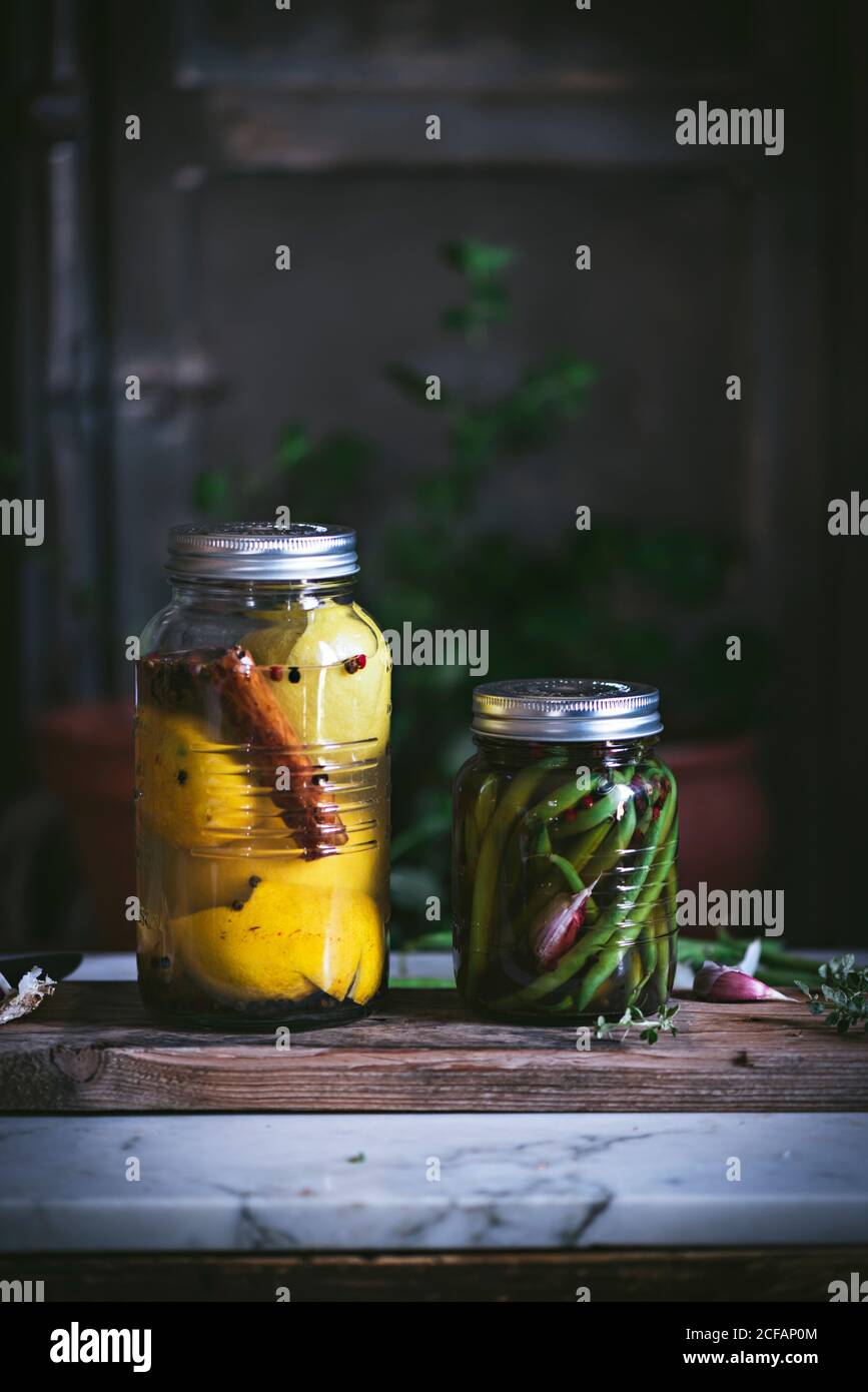 Transparent cylindrical glass container with marinated green beans and