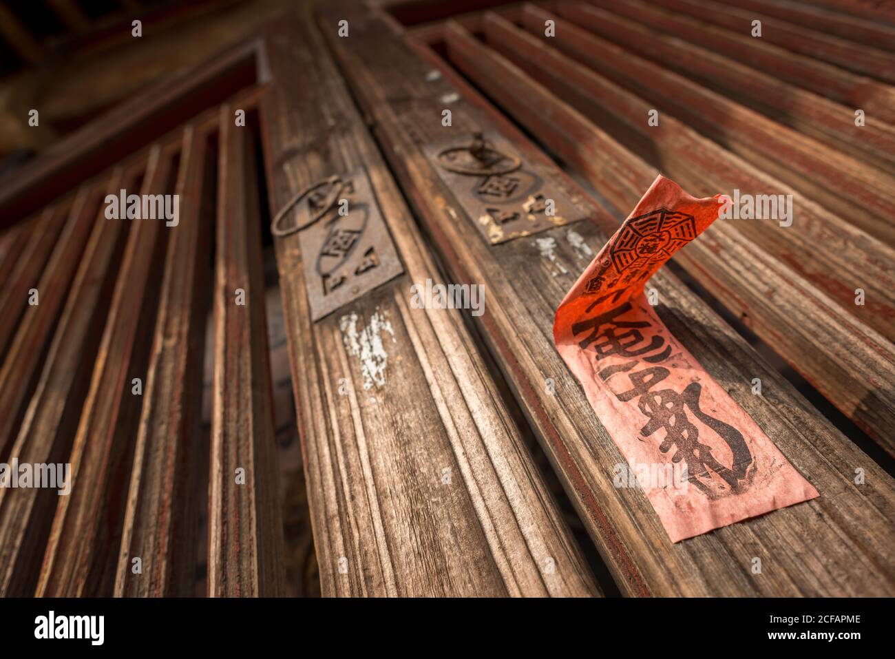 From below of old wooden door with metal knockers and red sticker with  hieroglyphs in Daimei Village Stock Photo - Alamy