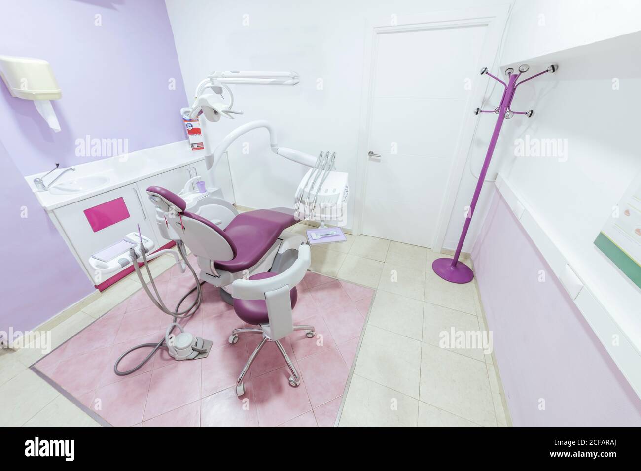 Interior of modern light empty dental office with chair and medical instruments and equipment placed around and white sink near wall Stock Photo