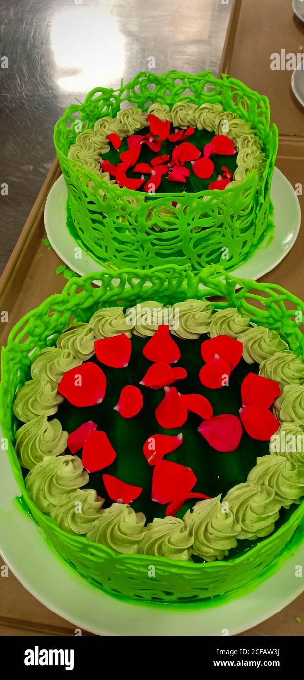 green tea cake garnished with red roses Stock Photo