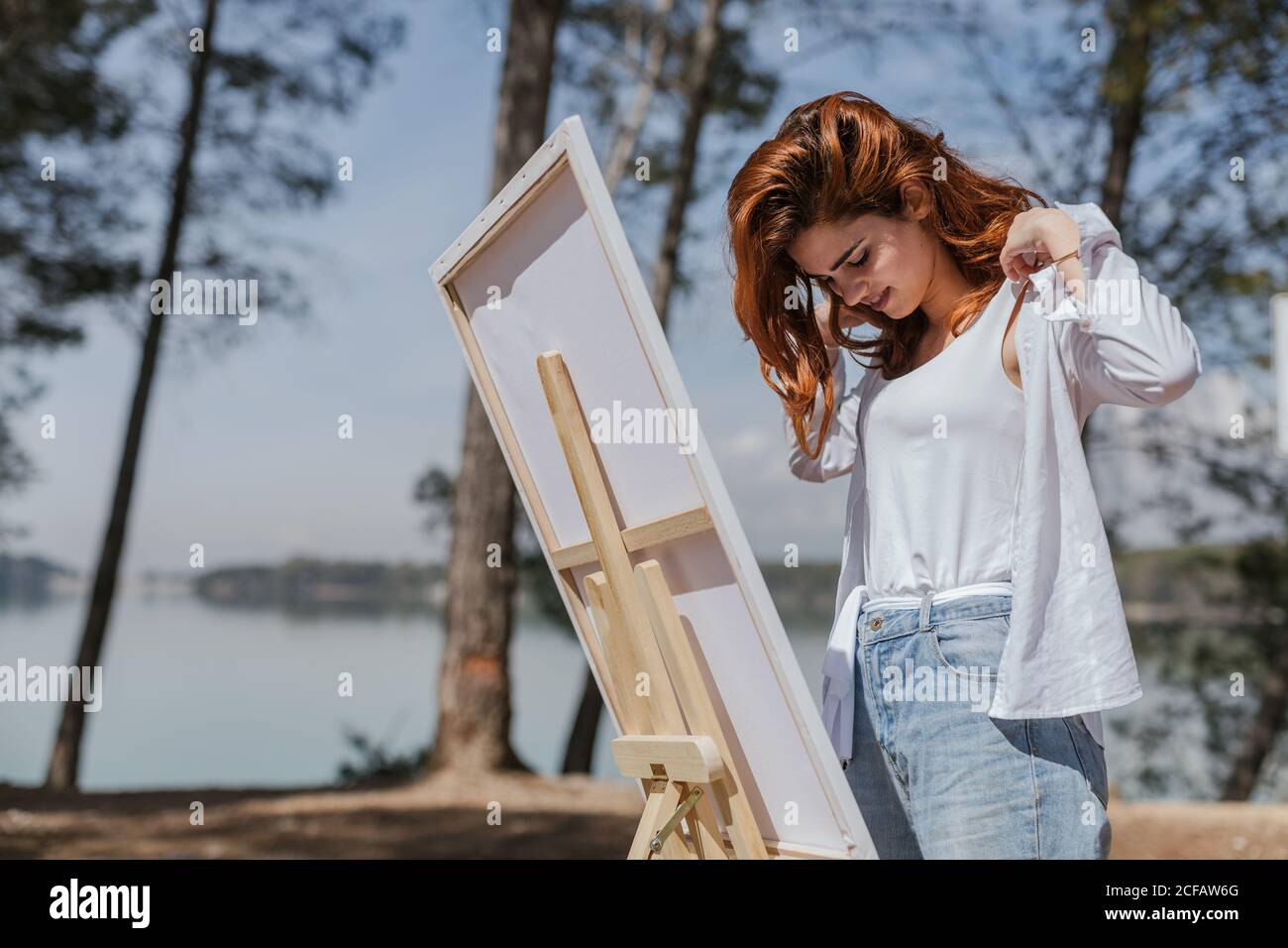 Young Woman putting on her shirt in countryside Stock Photo