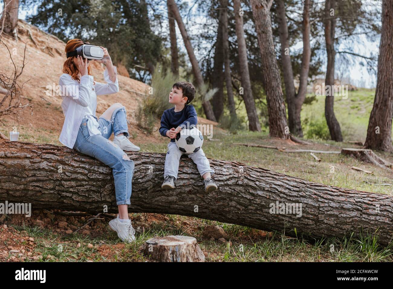 boy looking at mother in VR headset Stock Photo