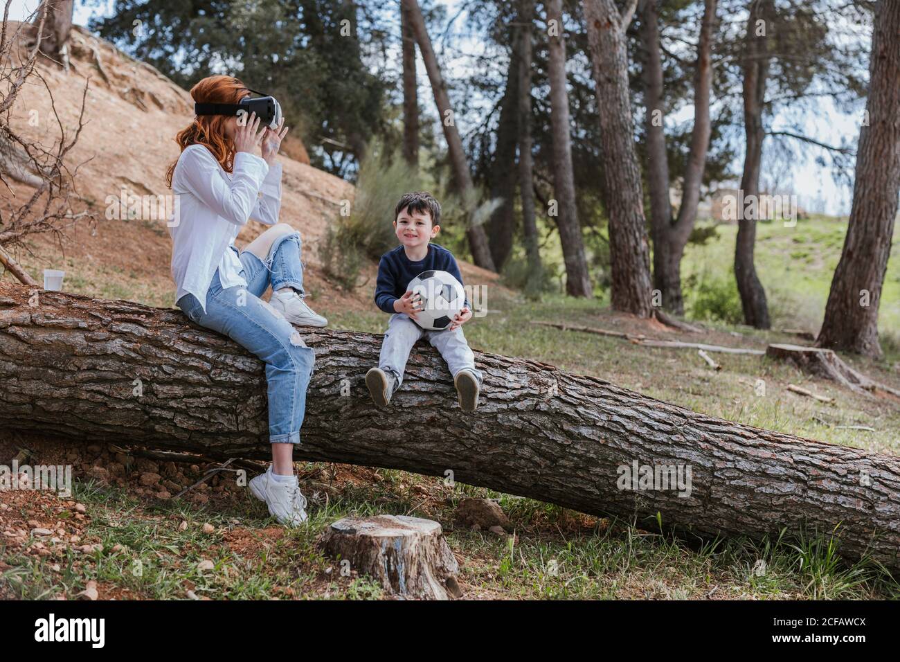 boy looking at mother in VR headset Stock Photo