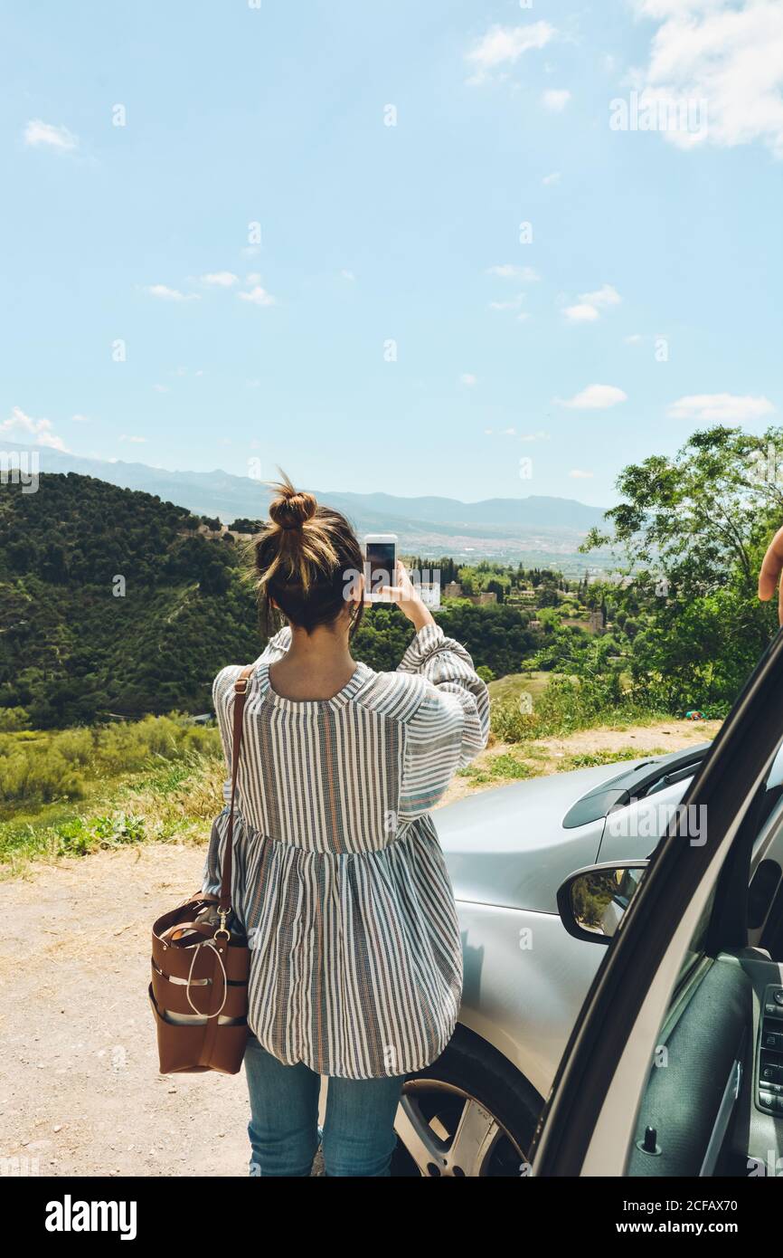 group of friends enjoying a conversation outside the car. They talk and selfies in a tourist place Stock Photo
