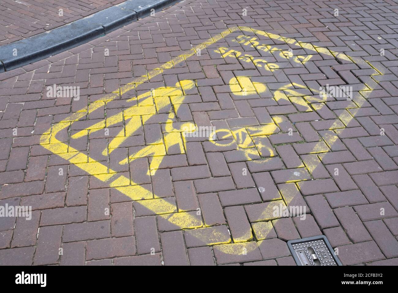 Yellow signs on the street indicate a Shared Space area in Amsterdam, a concept where priority and rules are lacking for traffic. Focus on the signs Stock Photo