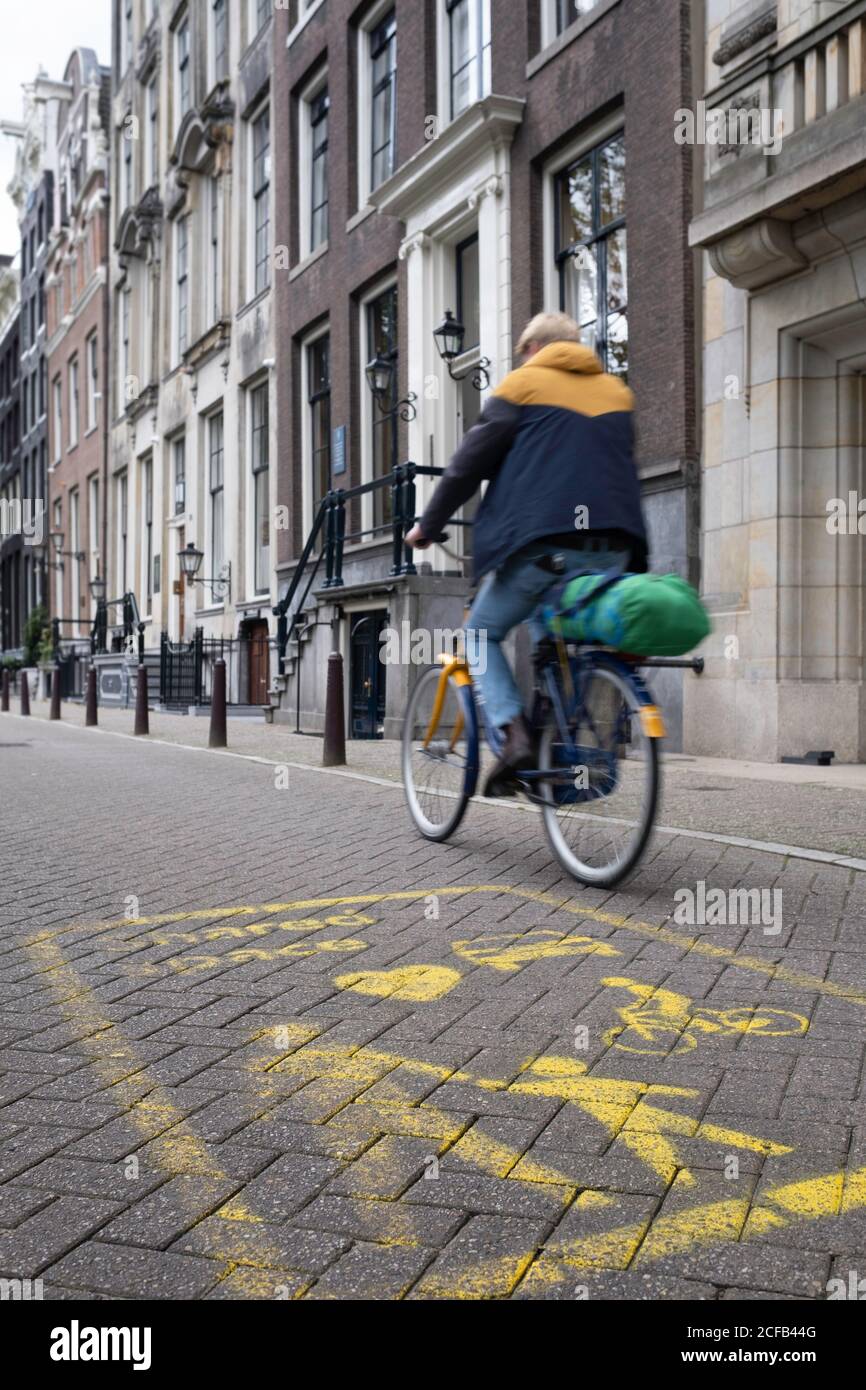 Yellow signs in focus on the street indicate a Shared Space area in Amsterdam, a concept where priority and rules are lacking for traffic Stock Photo
