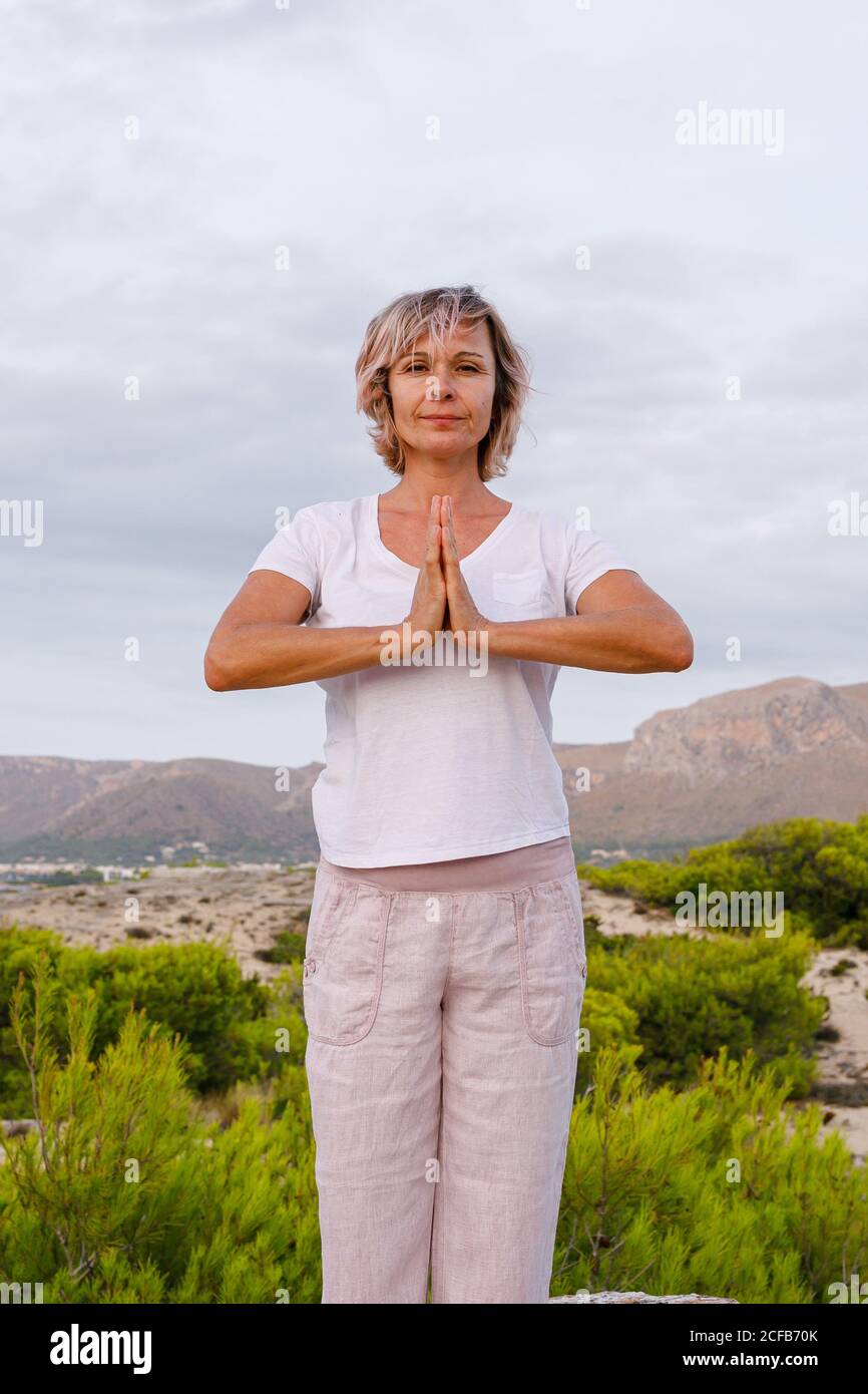 Barefoot Woman meditating on stone Stock Photo